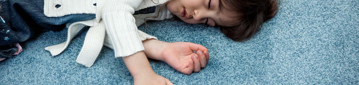 a little girl sleeping on tufted pile wall-to-wall carpet